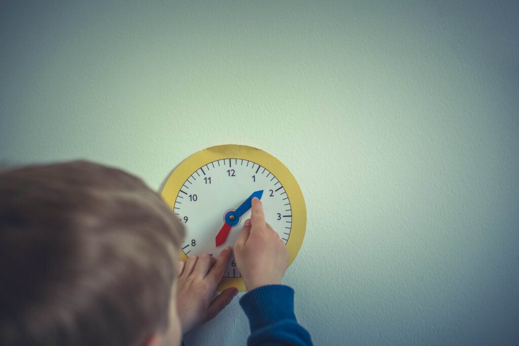 child playing with learners clock on wall